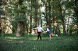 © soleg - young couple walking in the forest and playing guitar, summer nature, bright sunlight, shadows and green leaves, romantic feelings