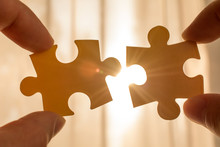 Two Hands Trying To Connect Couple Puzzle Piece. With Sunset Background. Symbol Of Association And Connection, Business Strategy, Completing, Team Support And Help Concept
