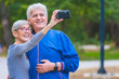 © lordn - Smiling senior couple in the park taking selfie