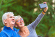 © lordn - Smiling senior couple in the park taking selfie
