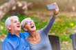 © lordn - Smiling senior couple in the park taking selfie