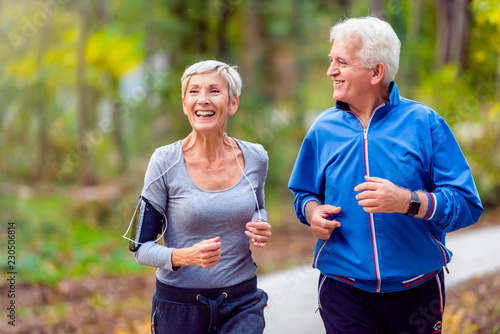 Fotografía Smiling senior active couple jogging together in the park