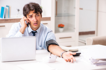 Man under stress measuring his blood pressure