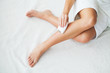 Skin care. Woman shaving her legs in bathroom