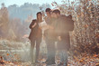 © Fxquadro - Group of young friends hiking in autumn colorful forest, looking at map and planning hike.
