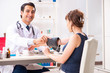 © Elnur - Young doctor checking woman's blood pressure