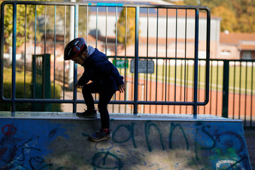 Glücklicher Junge im Skatepark im Herbst, Winter, Wald am Sportplatz