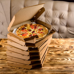 Canvas Print - pizza in box on wooden background, pizza delivery