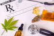 Assorted cannabis products, pills and cbd oil over medical prescription sheet