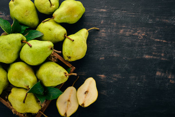 Wall Mural - Fresh pears. A large set of pears. Fruits. Free space for text. On a black wooden background. Top view.
