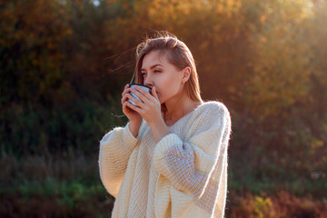 Wall Mural - Beautiful admiring woman drinking hot tea from thermos cup