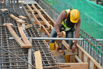 Construction workers fabricating timber form work at the construction site in Malacca, Malaysia. The form work was mainly made from timber and plywood. 