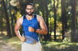 © proimagecontent - Young athletic multicultural bearded man wearing sportish glasses jogging and listening his favorite music, healthy lifestyle and people concept