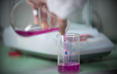 Chemical laboratory. Pouring liquid from one flask to another