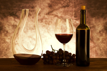 Wall Mural - Red wine. Glass of red wine, fresh grapes and decanter on wooden background.