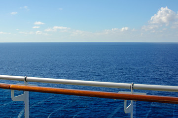 View from the deck of the cruise ship to the ocean. Sea horizon, clouds, blue tropical sky