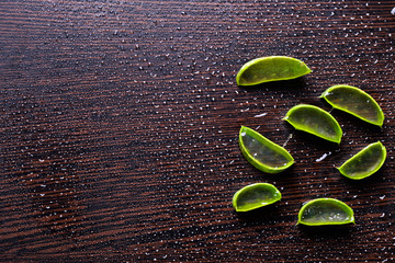 Canvas Print - top view of fresh aloe vera slices on table with water drops.