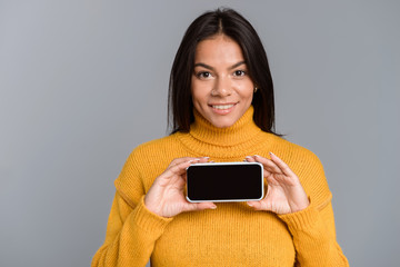 Poster - Amazing excited woman posing isolated over grey wall background showing display of mobile phone.