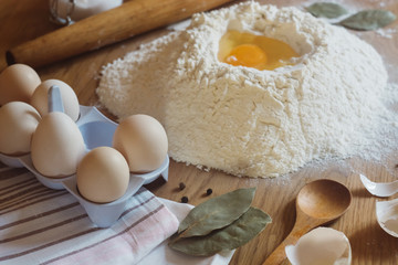 Preparation of the dough. flour powder, egg, spices on wooden background