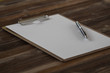 © Chunnapa - Clipboard with white sheet on wood background. Top view.Vintage style.