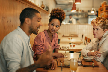 Wall Mural - Friends talking together over food and drinks in a bistro