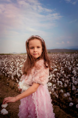 Wall Mural - Beautiful little girl with long hair and in pink dress in cotton field