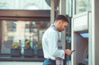 © qunica.com - Handsome businessman standing next to ATM