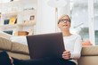 © contrastwerkstatt - Woman relaxing with her computer on a sofa at home
