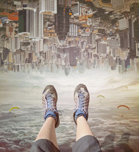 Legs Of A Woman  In Sneakers Relaxing In Sky.  Invert  City Upside Down .Future Modern Business Industry Concept: Big City On Amazing Sky  At Bangkok, Thailand, Asia