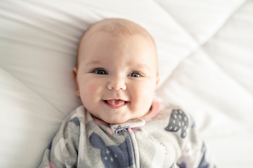 Wall Mural - A Cute baby girl on a white bed at home