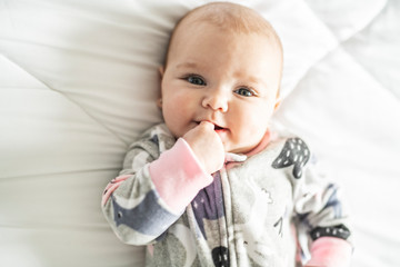 Wall Mural - A Cute baby girl on a white bed at home