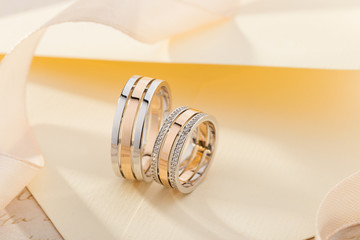 Pair of pink gold and white gold wedding ring with diamonds on female ring