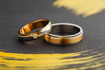  Two tone silver and gold wedding rings on black background