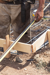 Wall Mural - Worker Measuring Steel Rebar At Construction Site