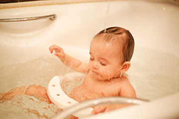 Seven-month-old beautiful girl bathes in the bathroom