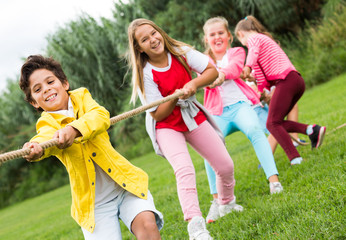 Cheerful children are competing and tug of war