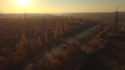 Wall Mural - Aerial: fly cam follow motorbike on the road at sunset time