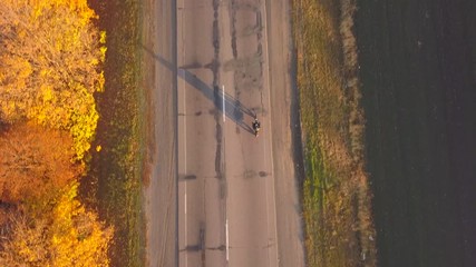 Wall Mural - Aerial: fly cam follow motorbike on the road at sunset time