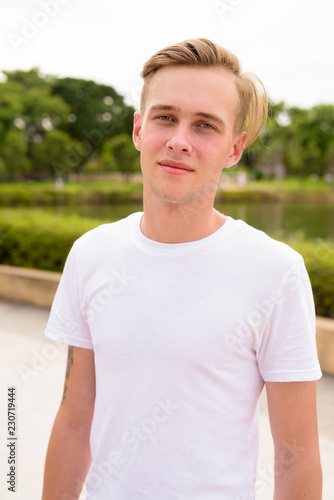 Young Handsome Man With Blond Hair Relaxing At The Park Buy This