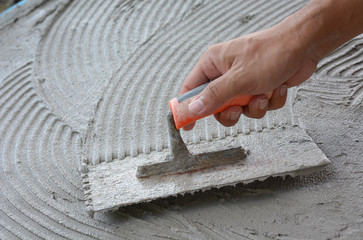 Hand on be bound with cement , do cement work, apply cement (over a surface)