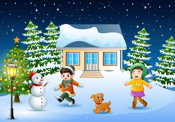 Wall Mural - Happy kids playing in front of the snowing house on christmas day