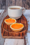 Fototapeta Kuchnia - Egg tart and a cup of coffee on wooden background