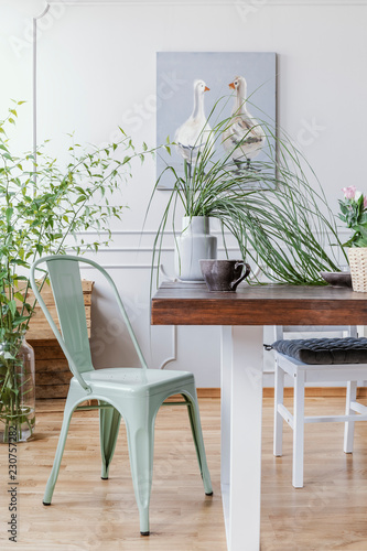 Vertical View Of Mint Green Chair Next To Wooden Table With