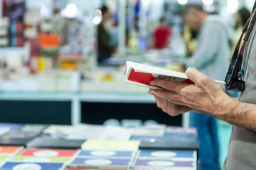 Man reading a book at the stand in a book fair