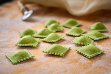 Wall Mural - uncooked homemade ravioli with flour on wooden background