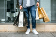 © David Pereiras - Low section of unrecognizable young man shopping with paper bags in his hand