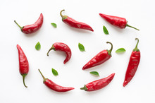 Red Hot Chilli Peppers With Green Leaves On White Background. Food Pattern. 