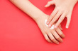 © Наталья Маяк - the woman's hand smeared her hand with cosmetic cream lotion with a copy of space on a red background of minimalism. The concept of women's pattern blog