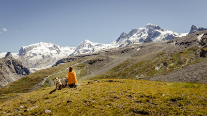 Dog and woman enjoying view in the swiss alps