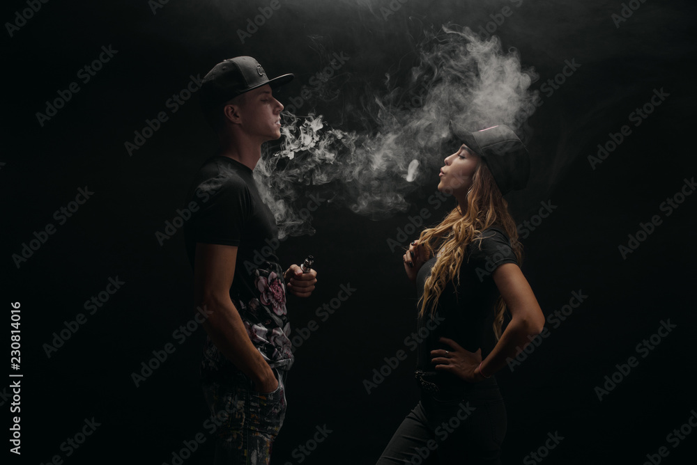 Couple vaping. Young man and woman blowing smoke to join it in one cloud at black studio background. Relationship and vape addiction concept with copy space Stock Photo | Adobe Stock Couple vaping. Young man and woman blowing smoke to join it in one cloud at black studio background. Relationship and vape addiction concept with copy space Stock Photo | Adobe Stock